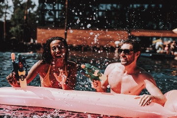 Wall Mural - Young Smiling Couple having Fun in Swimming Pool