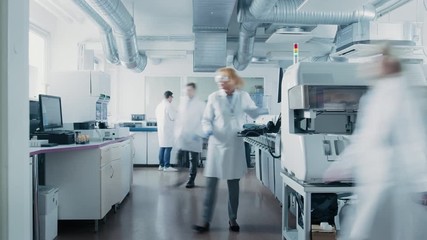 Wall Mural - time lapse shot of team of research scientists working on computer, with medical equipment, analyzin