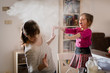 © Martinan - Girl throwing flour on mother during baking