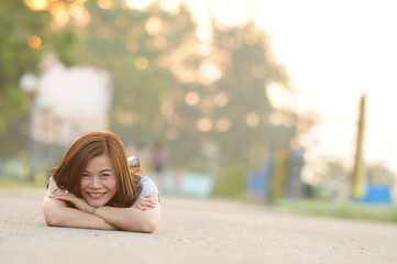 Asian girl smiling and feeling happy in the park in a sunny summer day, Have a beautiful day and happy concept.