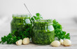 green sauce with garlic and oil in a glass jar