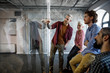 © LUMINA IMAGES - Group of casual young businesspeople having a working meeting in front of glass board.