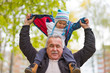 © yavdat - Playful grandfather spending time with his grandson in park on sunny day
