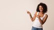 © Prostock-studio - Happy african-american woman showing at copy space