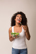 © Prostock-studio - Laughing woman eating healthy salad over light background