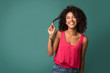 © Prostock-studio - African-american woman touching her curly hair on turquoise background