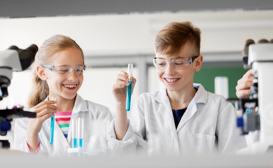 Sticker - education, science and children concept - kids with test tubes studying chemistry at school laboratory