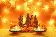 hindu god ram, sita, laxman, hanumaan statue with decorative lights, oil clay lamps and flowers for diwali celebration