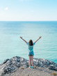 © ADDICTIVE STOCK - Happy woman with hands up against seascape