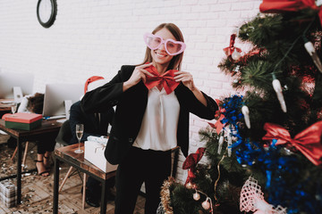 Wall Mural - Young Woman in Glasses Decorating Christmas Tree.