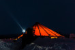 Norway. Photographer Dave Stevenson wearing head torch outside traditional Norwegian lavvu tent.