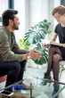 © alfa27 - psychotherapist consulting man, asking questions, interviewing man sitting on sofa. psychologist with client