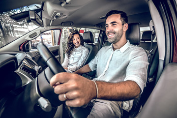 Wall Mural - Beautiful couple smiling while sitting in their new car