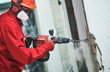 © Kadmy - worker with demolition hammer removing plaster or stucco from wall