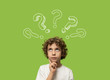 © Lomb - thinking kid - 6 years old child thinking and asking himself a question. Elementary school boy isolated on green background and question mark over his head