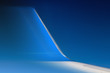 Part of fast moving jet wing, close view. The blurred winglet on a wing of plane when a flight in a blue sky.