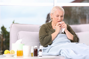 Ill mature woman suffering from cough at home. Space for text