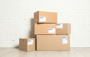 Sticker - Stack of parcel boxes on floor against brick wall