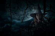 Halloween Witch Showing Silence Sign With Finger Over Lips Standing Over Dead Tree, Crow, Birds, Full Moon And Spooky Cloudy Sky, Halloween Mystery Concept