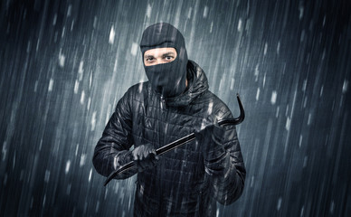 Wall Mural - Burglar in action in black clothes with rainy concept. 