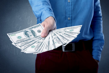 Wall Mural - Young businessman holding large amount of bills with grungy background