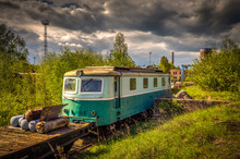 Old Locomotive Skoda 53E In Train Cemetery In The Summer With Green Grass And Trees In The Background And Great Cloudy Sky