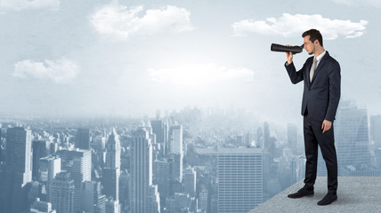 Wall Mural - businessman looking forward to a city with binoculars from skyscraper concept