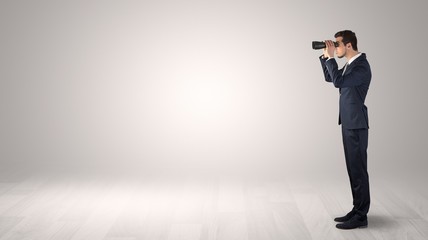 Wall Mural - businessman looking forward with binoculars in an empty space