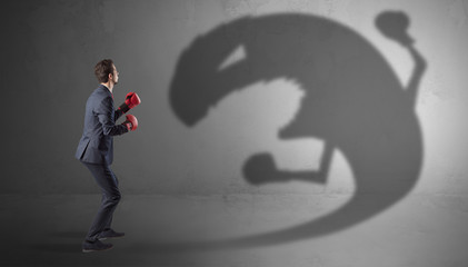 Canvas Print - Businessman with boxing glove fighting with a big monster shadow
