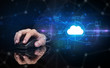 © ra2 studio - Hand using wireless mouse in a dark environment with cloud technology and online storage concept