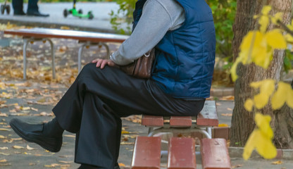 adult people sit on the bench outdoor on an autumn day f