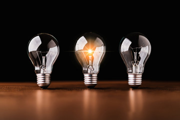 creativity startup business ideas concept with glow light bulb on black background