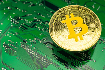 Golden bitcoin virtual money on digital circuit board computer. Concept of blockchain technology, digital money, e-wallet, cryptocurrency mining. Bitcoin is a cryptocurrency form of electronic cash.