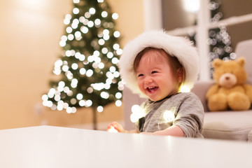 Happy toddler boy with a Santa hat playing on Christmas