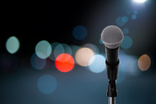 Microphone On Stage ..Close Up Of Microphone Setting On Stand With Colorful Light Bokeh Background In Concert Hall ,showbiz Concept.