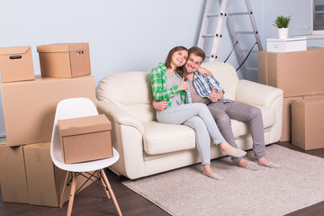 Relocation, real estate and moving concept - young couple people moved to a new apartment