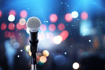 microphone on stage ..close up of microphone setting on stand with colorful light bokeh background i
