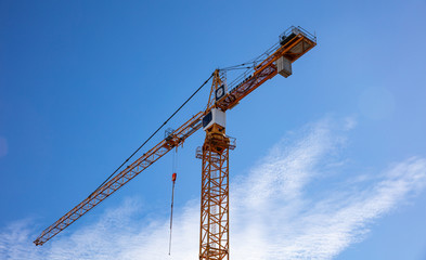 Red tower crane on blue sky background