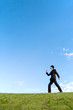 © chikala - 青空をバックに前進する若いビジネスマン1人。元気・成功・目標・挑戦イメージ