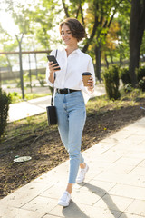 Canvas Print - Smiling young woman walking at the street