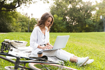 Poster - Lovely young woman bicyclist spending time at the park