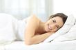 © Antonioguillem - Smiley woman lying on the bed looking at you