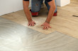 © leomalsam - Work on laying flooring. Worker installing new vinyl tile floor.