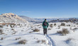 Man hiking snow-covered Desert Voices Trail in Dinosaur National Monument 