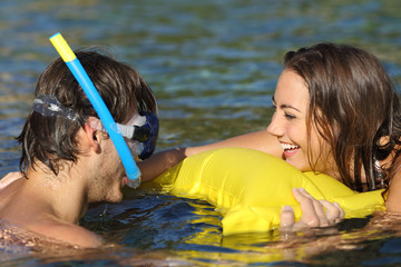 Wall Mural - Happy couple of tourists joking bathing on the beach