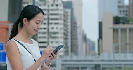 Canvas Print - Woman sending sms on cellphone in city