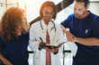 © Flamingo Images - Smiling doctor discussing paperwork with two interns in a hospit