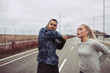 Couple in sportswear stretching before jogging on a country road