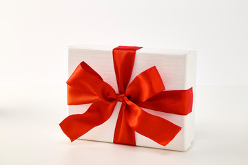 White gift box with red ribbon bow