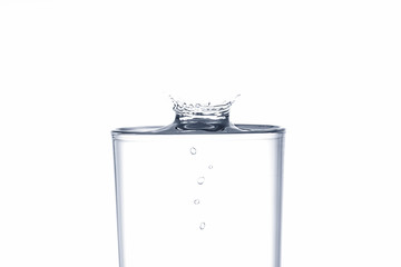 Wall Mural - Water drop splash on drinking glass on white background